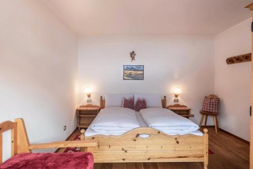 a bedroom with a wooden bed and two tables at Casa Rustica App Saslonch in Ortisei