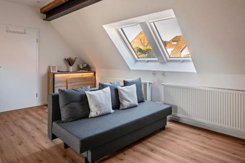a couch in a living room with two windows at Fewo Schmidt in Bahlingen