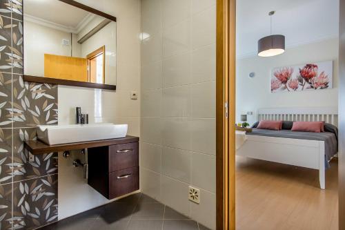 une salle de bain avec un lavabo et un miroir dans l'établissement Villa Casa Vilas Boas, à Albufeira