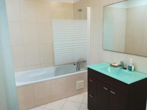 Un baño con lavabo, bañera y espejo. en T2 Furadouro 30m from the beach, en Furadouro