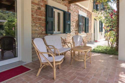 a patio with chairs and a table and a building at Cascina Oddone Prati Winery in Strevi