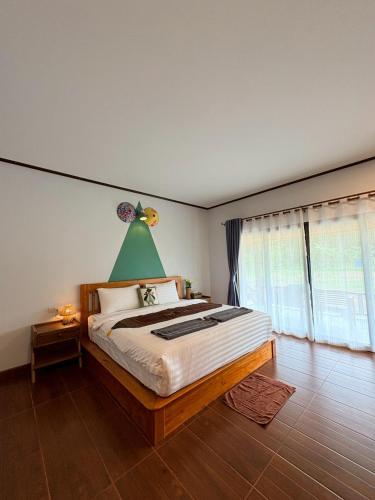 a bedroom with a bed with a green lamp above it at Baan I Ta Lay Koh Yao Noi in Ko Yao Noi