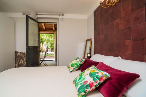 a bedroom with a white bed with two pillows at A Ugghia- Dependance in Fiumefreddo di Sicilia
