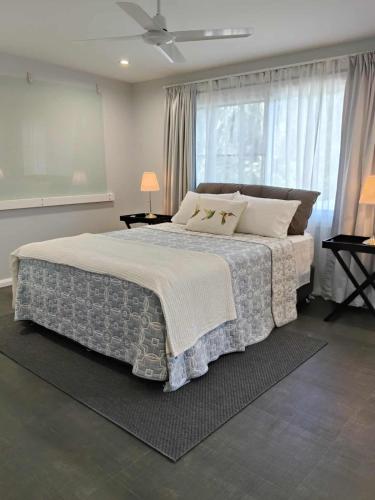 a bedroom with a large bed and a window at Carefree Comfort in Deception Bay
