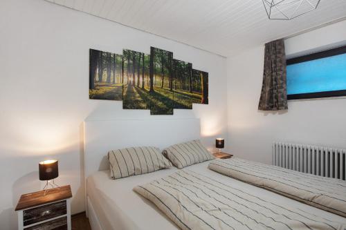 ザンクト・ブラージエンにあるSchwarzwaldglückのベッドルーム1室(壁に絵画3点が飾られたベッド1台付)