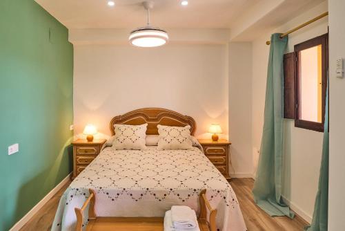 ein Schlafzimmer mit einem Bett mit zwei Stühlen und zwei Lampen in der Unterkunft Holiday House Dehesa del Colmenar in Cabra