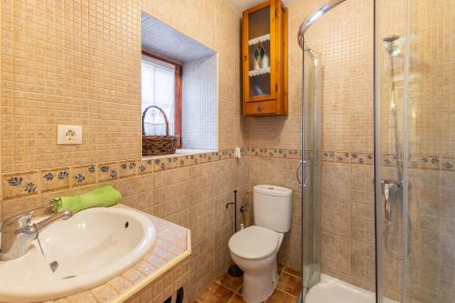 a bathroom with a toilet and a sink and a shower at Casa Siesta y Brisca in Manjabálago