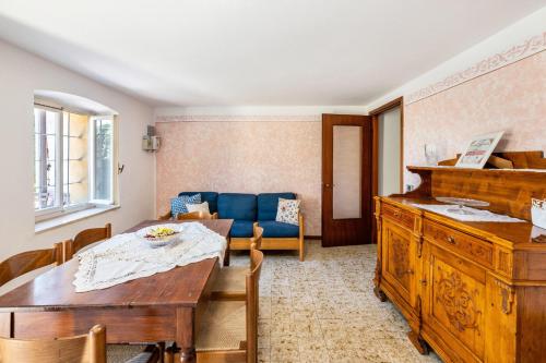 a living room with a table and a blue couch at La casa di Delfina in Caprino Veronese