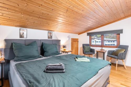 a bedroom with a large bed with a wooden ceiling at Haus an der Ache in Fieberbrunn