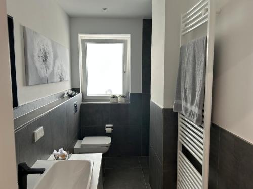 a bathroom with a white sink and a toilet at Stadtquartier Ahaus in Ahaus