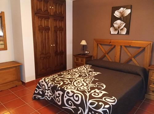 a bedroom with a bed with a black and white blanket at Casa de la Calle el Pozo in Pina de Montolgrao