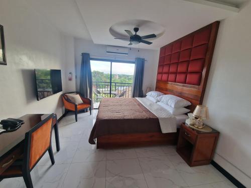 a bedroom with a bed and a desk and a window at A cozy and spacious Studio apartment Angeles city pampanga in Angeles