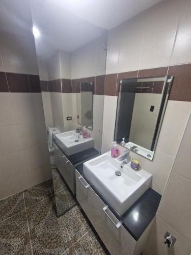 a bathroom with two sinks and two mirrors at A cozy and spacious Studio apartment Angeles city pampanga in Angeles