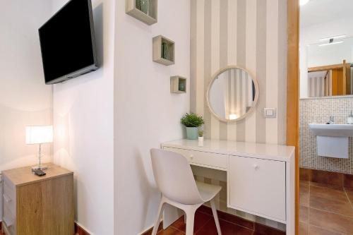 ein Badezimmer mit Schreibtisch, Waschbecken und Spiegel in der Unterkunft Villa Valeria in Corralejo