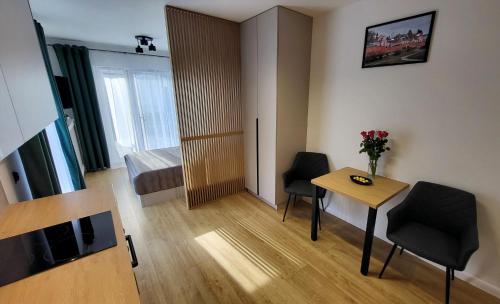 a small room with a table and chairs and a bedroom at Apartament Anna przy Starówce in Zamość