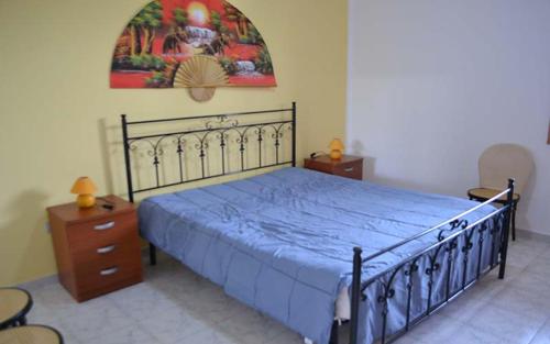 ein Schlafzimmer mit einem blauen Bett und einem Gemälde an der Wand in der Unterkunft Casa a Torre dell Orso Pt55 in Torre dell'Orso