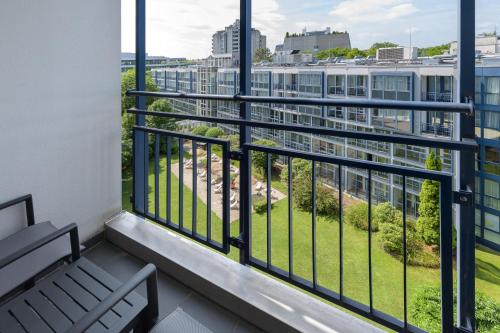 a balcony with a bench and a view of the city at Pullman Munich in Munich