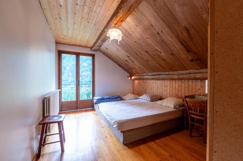 Un dormitorio con una cama y un techo de madera. en Maison du cloz, en La Lechere