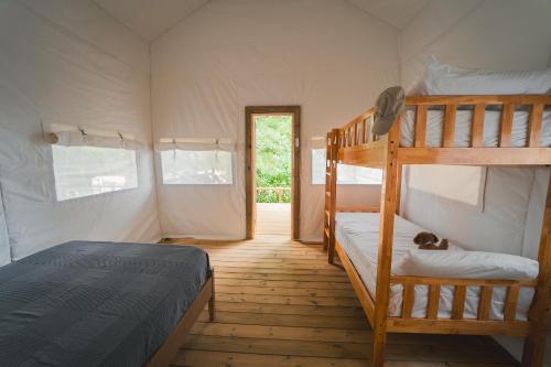 HolaCamp Vall Natura في Sant Miquel de Campmajor: غرفة نوم بسريرين بطابقين ومدخل