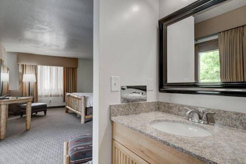 a bathroom with a sink and a room with a bedroom at Ridgeline Hotel at Yellowstone, an Ascend Collection Hotel in Gardiner