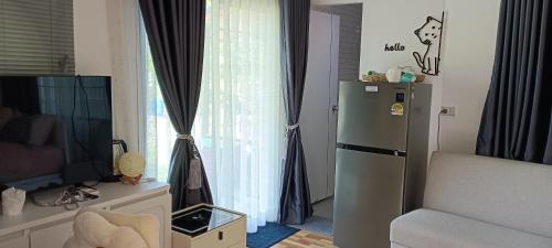 Una sala de estar con refrigerador y una ventana. en Lhong Luk Khao Camping, en Ban Khlong Kathon