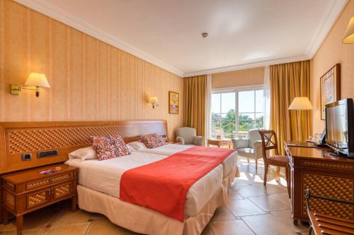 une chambre d'hôtel avec un lit et une télévision dans l'établissement Hotel Cordial Mogán Playa, à Puerto de Mogán