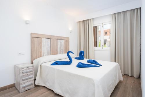two blue swans sitting on top of a bed at Apartamento Venecia in Alcudia