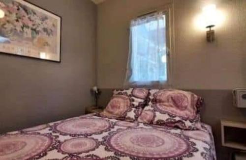 アルジェレス・シュル・メールにあるAppartement proche merの小さなベッドルーム(花の咲く毛布付きのベッド付)