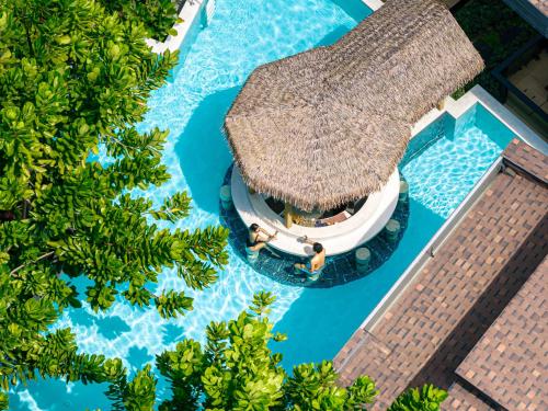 an overhead view of a resort pool with a thatch roof at La Miniera Pool Villas Pattaya - Small Luxury Hotels of the World in Nong Prue