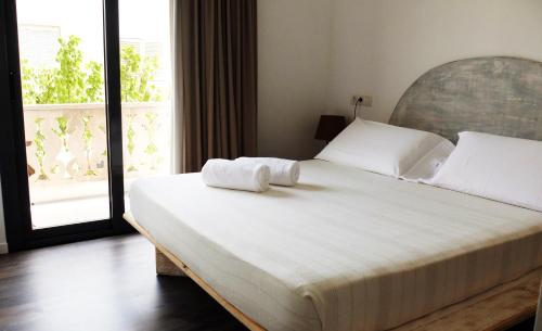 a bedroom with a large bed with two towels on it at Hostal Bon Sol in Sant Ferran de Ses Roques