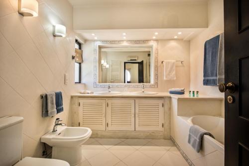 a bathroom with a sink and a toilet and a mirror at Mng Elliott25 in Vale do Lobo