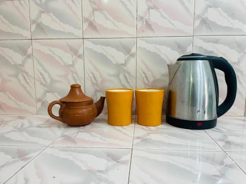 a tea kettle and two cups on a counter at Lakru Home Stay in Weligama