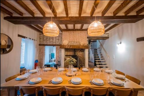 a large dining room with a large table and a fireplace at Gîte Bellarca avec piscine et spa in Soucelles