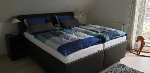 a bed with blue and white sheets and blue pillows at Ferienwohnung Feuerbach in Telgte