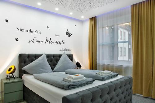 une chambre avec un lit avec un panneau sur le mur dans l'établissement Modern Apartments Neuburg 1 - New, à Neubourg-sur-le-Danube