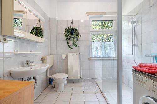 a white bathroom with a toilet and a sink at Ferienhaus Feldblick in Karwitz