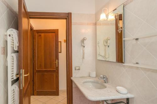 een badkamer met een wastafel en een telefoon aan de muur bij Il Girasole - Malva in Venturina Terme