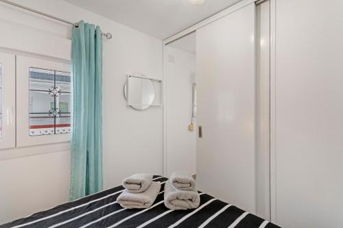 a bedroom with a bed with towels on it at Casa Paula - 21 in Arinaga