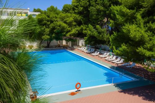 an overhead view of a swimming pool with chairs and trees at Hotiday Vieste Centro in Vieste