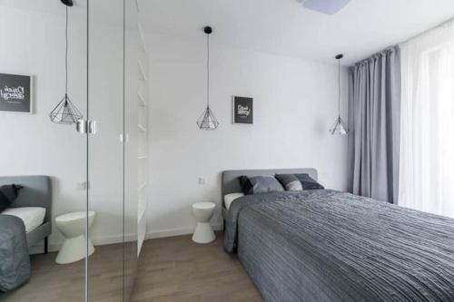 Un dormitorio con una cama y una pared de cristal. en Exclusive Apartments on Kasprzaka Street - Warsaw Wola, en Varsovia