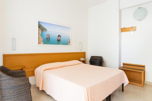 a bedroom with a bed and a picture on the wall at Hotiday Vieste Centro in Vieste