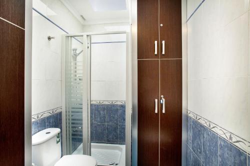 a bathroom with a toilet and a glass shower at Sun and Beach Bahia Feliz 1 in San Agustin
