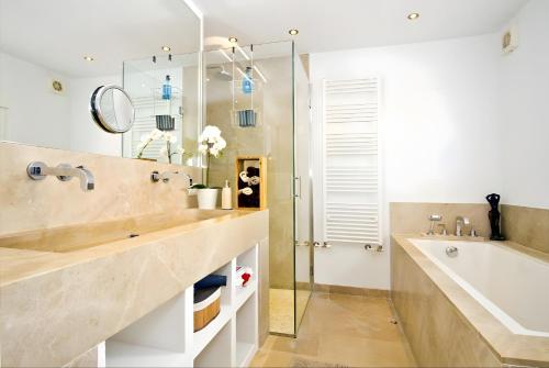 a bathroom with a sink and a tub and a mirror at Villa Blanca in Capdepera