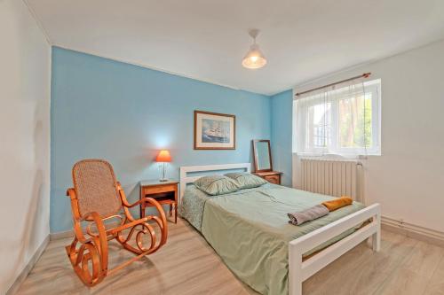 une chambre avec un lit et une chaise dedans dans l'établissement Location meublé Ty Kim, à Le Folgoët