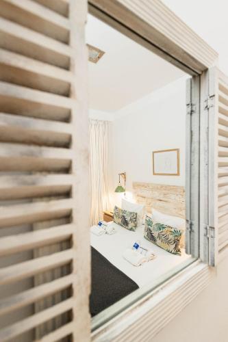 a mirror reflection of a room with a bed and chairs at Hostal Vidamia in Málaga
