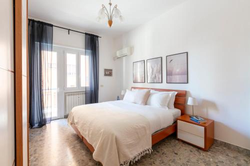 a white bedroom with a bed and a window at Casa Laberio by Hili in Rome