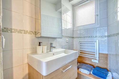 a white bathroom with a sink and a mirror at Chez Christian in Bordeaux