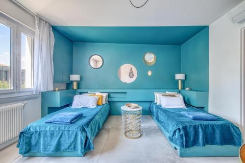 two beds in a room with blue walls at Chez Christian in Bordeaux