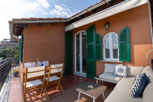 une terrasse avec des volets verts, un canapé et une table dans l'établissement La Casetta di Riccardo - Terrace Sea View, à Portovenere