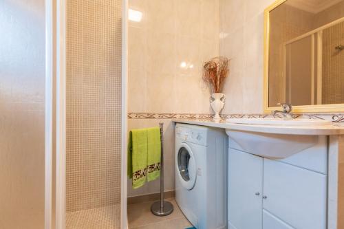 een badkamer met een wasmachine en een wastafel bij 10T2 by AlgarveManta in Manta Rota